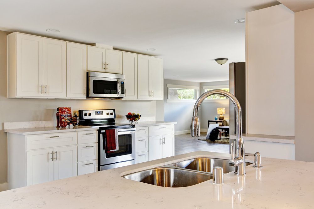 Bright kitchen room with steel appliances and granite tops